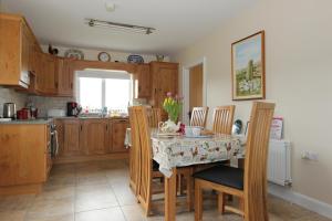 cocina con mesa y sillas y cocina con fregadero en Pat Larry's Cottage, en Greencastle