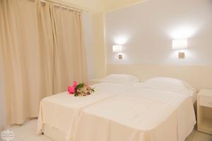 un dormitorio blanco con 2 camas con flores. en Casa di Stassa, en Parga