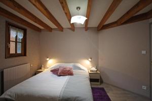 Un dormitorio con una cama grande en una habitación con techos de madera. en Les jumeaux en Granges-sur-Vologne