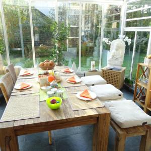 a wooden table with food on it in a room with windows at Wohlfühlhaus Immenstaad in Immenstaad am Bodensee