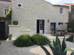 een stenen huis met een binnenplaats en een patio bij La Maison du Baloir in Thairé