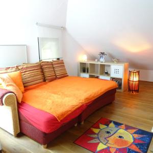 a bedroom with a bed with an orange bedspread at Wohlfühlhaus Immenstaad in Immenstaad am Bodensee