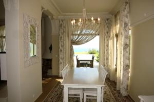 a dining room with a white table and a chandelier at Private Villa First line with sea view in BlackSeaRama Golf A PLUS LOCATION PRIVACY POOL in Balchik +112 photos