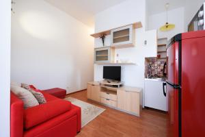 a living room with a red couch and a refrigerator at Apartment Lola Maria in Zadar