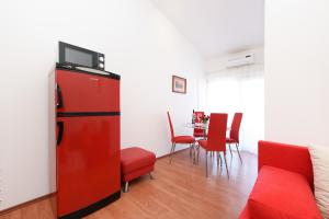 a red refrigerator in a living room with a table at Apartment Lola Maria in Zadar