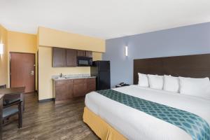 um quarto de hotel com uma cama grande e uma cozinha em Days Inn by Wyndham New Orleans Pontchartrain em Nova Orleães