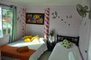 Un dormitorio con dos camas y un ventilador. en Hostel Stingray, en San Andrés