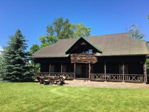 a large log cabin with benches in the grass at Kaimo sodyba Senas rublis in Pesčiai +61 photos