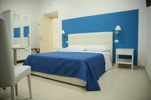 a blue bedroom with a bed and a blue wall at Il Gioiellino Lifestyle in Naples