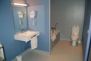 La salle de bains bleue est pourvue d'un lavabo et de toilettes. dans l'établissement Hôtel Bertrand, à Bar-le-Duc