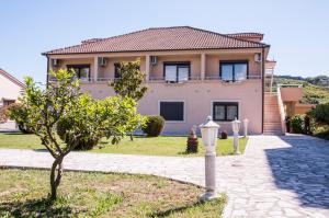 una casa con un árbol delante en Apartments Rudovic, en Ulcinj