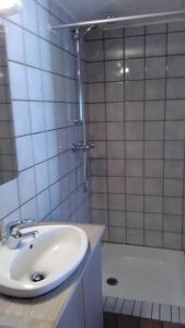 y baño blanco con lavabo y ducha. en Le Reposion en Saint-Amé
