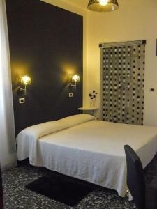 トリノにあるホテル ヴィットリアーノの白いベッドと黒い壁のベッドルーム1室
