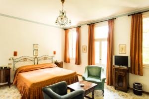 a bedroom with a bed and two chairs and a television at Residenza d'Epoca Albergo Quattro Fontane in Venice-Lido