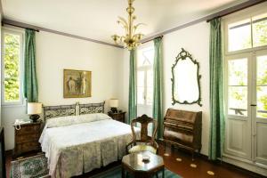 a bedroom with a bed and a mirror and a chair at Residenza d'Epoca Albergo Quattro Fontane in Venice-Lido