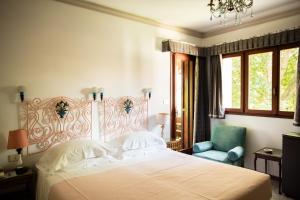 a bedroom with a large bed and a blue chair at Residenza d'Epoca Albergo Quattro Fontane in Venice-Lido