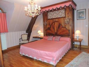 Schlafzimmer mit einem großen Bett mit einem Kopfteil aus Holz in der Unterkunft Domaine de La Vitrolle in Limeuil
