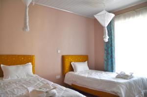 sypialnia z 2 łóżkami i oknem w obiekcie Lamanis Haven w mieście Kakamega
