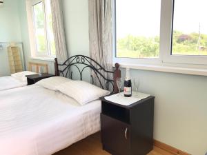 a bedroom with two beds and two glasses of wine at Vse Dlya Vas Guest House in Gudauta