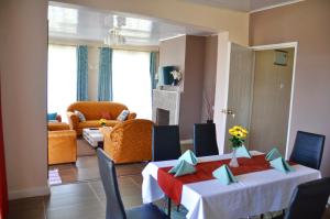 Habitación con mesa, sillas y sala de estar. en Lamanis Haven en Kakamega