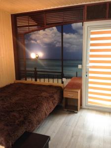 a bedroom with a large window with a view of the ocean at Poilsiavietė Mano Maljorka in Šventoji