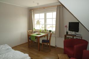 a room with a table and a chair and a window at Appartements Fischerhus in Glowe
