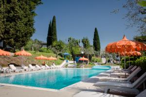 a pool at a resort with chairs and umbrellas at Hotel Mon Repos in Sirmione