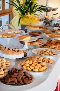 una tavola piena di piatti e biscotti di Hotel Mon Repos a Sirmione