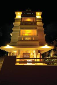 een verlicht gebouw met 's nachts een toren bij Casa Allay in Cochin