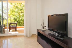 una sala de estar con TV de pantalla plana en una cómoda en Cozy Rentals Princess - Sun, Golf, Mountain, en Mijas