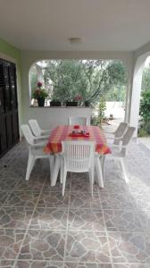 - une table et des chaises blanches sur la terrasse dans l'établissement Apartment Peris, à Sevid