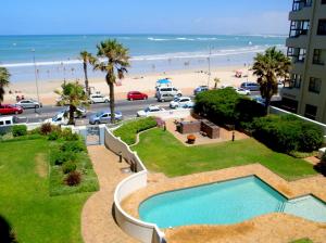 a view of the beach from the balcony of a resort at Beach front property in Strand