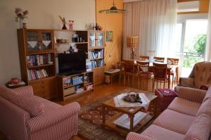 Anastasia Apartment في كافالا: غرفة معيشة بها كنب وتلفزيون وطاولة