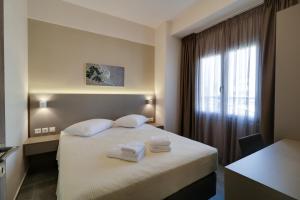 une chambre d'hôtel avec un lit et des serviettes. dans l'établissement Athens Comfort, à Athènes