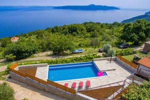 an outdoor swimming pool with a view of the water at House Obrš in Mošćenička Draga