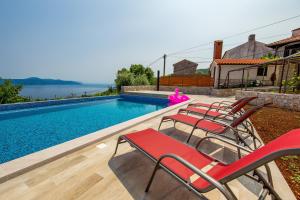 a group of chairs sitting next to a swimming pool at House Obrš in Mošćenička Draga