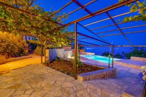 an estate with a swimming pool and a pergola at House Obrš in Mošćenička Draga