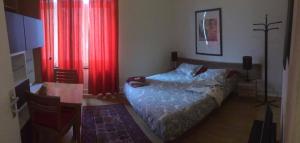 a bedroom with a bed and a table and red curtains at Appart-hôtel Maison de la Lune - petite Auberge d'Etterbeek in Brussels