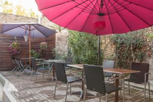 a patio with tables and chairs with umbrellas at Logis Auberge La Cremaillere in Villandraut