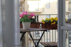 Un balcón con una mesa con flores. en B&B Carolina Napoli-Vomero en Nápoles