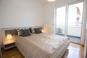 ein Schlafzimmer mit einem großen Bett und einem großen Fenster in der Unterkunft Jelena Apartment in Doboj