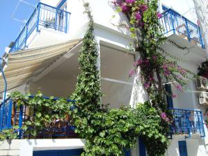 a building with blue balconies and flowers on it at Vakhos in Naxos Chora
