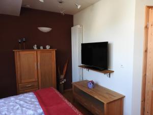 a bedroom with a bed and a flat screen tv at Sweet Home Suite in Hallerndorf