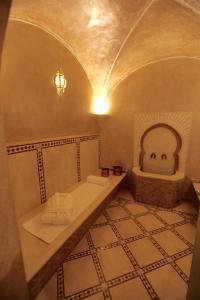 a bathroom with a sink and a tub with a face on it at Riad Dar Haven in Tamraght Ou Fella