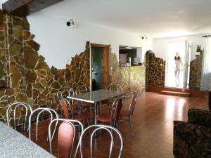 a table and chairs in a room with a stone wall at Pensiunea Jianu in Albac