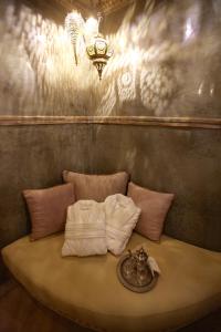 a room with a bed with two pillows and a lamp at Riad Dar Haven in Tamraght Ou Fella