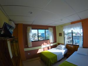 a bedroom with two beds and a window at Dolphin House in Puerto Baquerizo Moreno