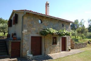 a small stone house with two garage at OlivaHouse in Marezige
