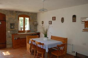 a dining room with a table and chairs and a kitchen at OlivaHouse in Marezige