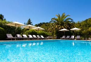 a swimming pool with chairs and umbrellas at Les Vergers de Saint Paul in Saint Paul de Vence